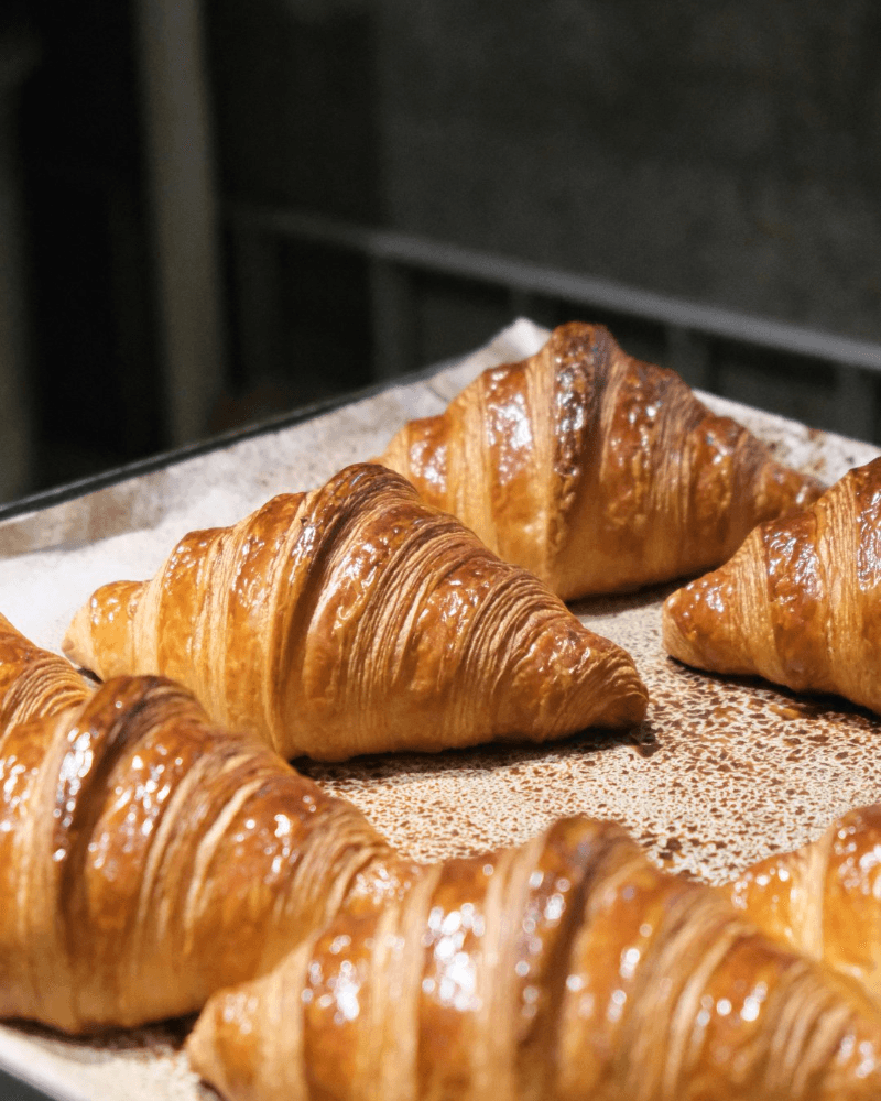 Croissants dorés fraîchement sortis du four sur une plaque de cuisson